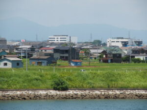 汐合大橋（五十鈴川）から遠望した「鶴松田について」説明板が掲示された小屋