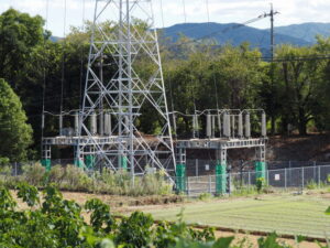 特別高圧電力ケーブルが地下へと隠れる鉄塔（JR参宮線宮川橋梁東詰付近）