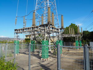 鉄塔から地下へと隠れる特別高圧電力ケーブル（JR参宮線宮川橋梁東詰付近）