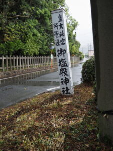 傾いている御塩殿神社の社号標